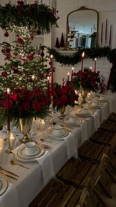 a table set for christmas dinner with candles and decorations