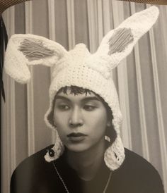 a woman wearing a crocheted bunny hat with ears on it's head