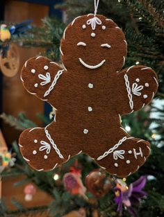 a christmas tree ornament with a gingerbread man hanging from it's side