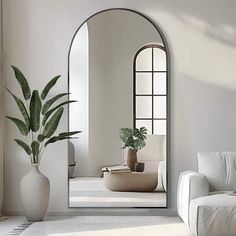 a living room with white furniture and a large mirror