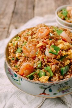 a bowl filled with rice and shrimp on top of a table