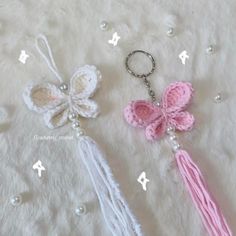 two crocheted keychains with tassels and beads on a white background