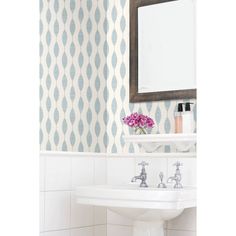 a white sink sitting under a bathroom mirror next to a wall mounted faucet