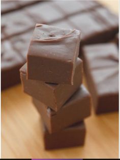 several pieces of chocolate sitting on top of a wooden table next to another piece of chocolate