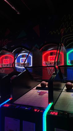 several basketball hoops are lit up in the dark with neon lights and balls on them