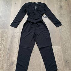 This Beautiful Jumpsuit From Express Features A Deep V-Neck, With Tie Belt At The Waist, Long Sleeves, Slash Pockets And A Tapered Leg. Msrp $108 Size Small Color Black Solid Long Sleeve Pantsuit For Party, Black Bodysuit For Workwear In Spring, Spring Workwear Black Bodysuit, Solid V-neck Bodysuit For Work, V-neck Bodysuit For Workwear, Black Bodysuit For Spring Workwear, Black Bodysuit For Work In Spring, Black Formal Jumpsuits And Rompers For Fall, Fitted V-neck Formal Bodysuit