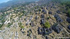 an aerial view of a cemetery in the middle of a mountain range with lots of trees