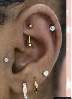 an ear with three different types of piercings on it's side and the top part of its ear