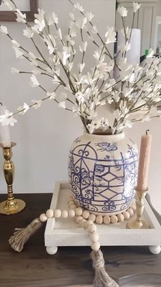 a blue and white vase sitting on top of a table next to a candle holder