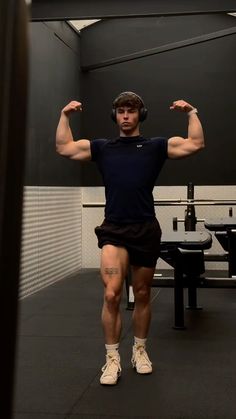 a man in shorts and headphones is flexing his muscles