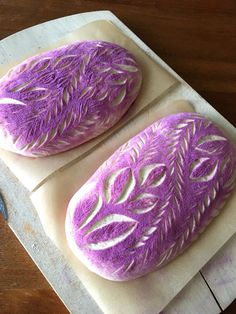 two purple cakes sitting on top of a white plate next to each other, with the words cake used to powder to give these loaves their burst color