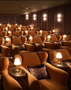 an empty theater with rows of chairs and lamps on the side tables in front of them