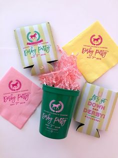 four different types of candy bags in a green cup with pink and yellow confetti