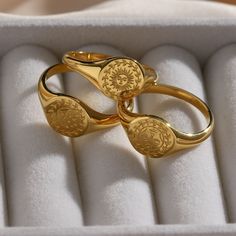 two gold rings sitting in a white box