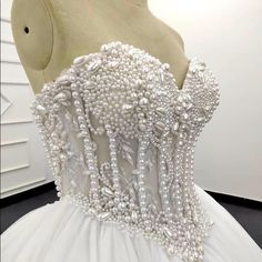 a white wedding dress with pearls on it