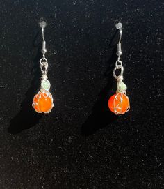 Orange dyed agate pumpkin earrings wire wrapped in silver colored copper with green accent beads Orange Jade Jewelry Gift, Nickel Free Carnelian Orange Earrings, Carnelian Wire Wrapped Earrings As Gift, Carnelian Wire Wrapped Earrings For Gift, Handmade Carnelian Orange Earrings, Handmade Orange Carnelian Earrings, Gift Carnelian Wire Wrapped Earrings, Distinctive Silver Wire Wrapped Beaded Earrings, Unique Silver Wire Wrapped Beaded Earrings