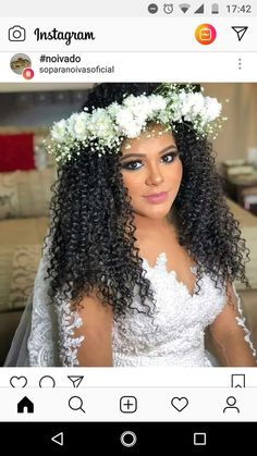 a woman with long hair wearing a white dress and flowers in her hair is looking at the camera