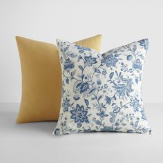 two blue and white pillows sitting next to each other