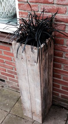 a wooden planter sitting next to a brick wall