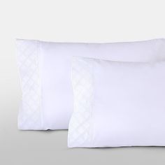 two white pillows sitting next to each other