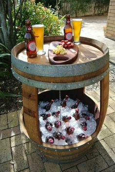 an old barrel turned into a bar with ice and beer