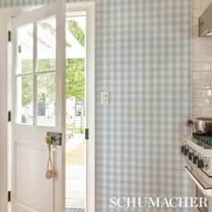 an open door leading to a kitchen with blue and white checkered walls