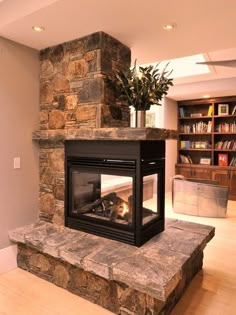 a living room with a stone fireplace and bookcases