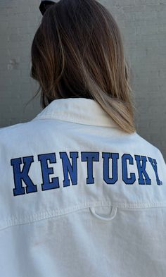 The pop of blue your game day look needed to cheer on our CATS! Wear this jacket oversized with a leather skort for a classic, but edgy look! This oversized jacket features a classic snap button front, collar, pocket and rounded hem to make a perfect breezy denim overshirt! Model is 5'6" with a 32DD bust, 27" waist, 36" hips, and wearing a large for a more oversized fit. Model usually wears size 2/4. Designed to fit oversized for an effortless and relaxed look. Stay true to size or size up for e School Spirit Long Sleeve Outerwear For Game Day, Collegiate Cotton Outerwear For Game Day, Casual Fall Outerwear For Game Day, White College Style Outerwear For Game Day, Casual Button-up Varsity Jacket For College, Casual College Varsity Jacket Button-up, School Spirit Cotton Outerwear For Game Day, Retro Fall Outerwear For Game Day, Retro Outerwear For Game Day In Fall