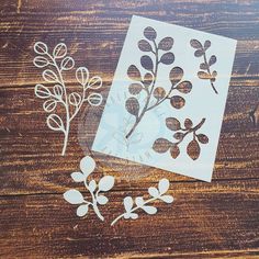 some cut outs are laying on a wooden surface with leaves and flowers in them,