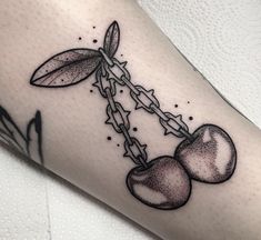 a tattoo with two cherries attached to it