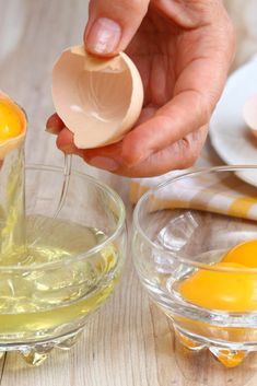 someone is pouring an egg into a glass bowl