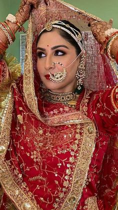 a woman in a red and gold bridal outfit