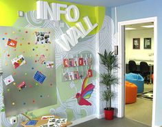 the office is decorated with colorful wallpaper and pictures on the walls, along with a plant