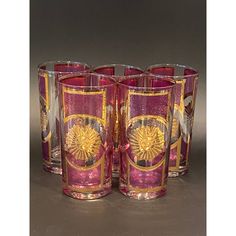 four pink and gold glass tumblers sitting next to each other