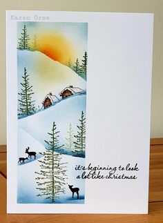 a christmas card with an image of two deer in the snow and trees on it