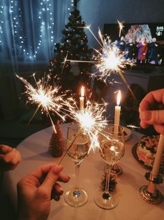 two people are toasting with sparklers on the table