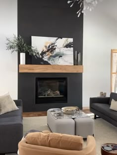 a living room filled with furniture and a large painting on the wall above it's fireplace