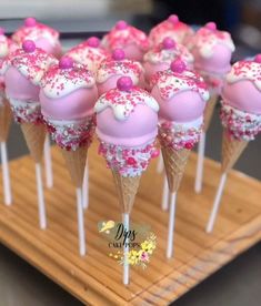 pink and white cake pops with sprinkles on wooden platter, ready to be eaten