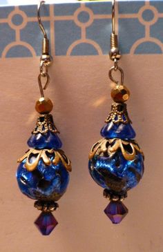 "Quality designed using mixed materials including a gorgeous, large vintage bead, golden filigree caps, and a sparkling blueish purple Swarovski crystal, these dazzling one-of-a-kind earrings hang about 1 1/2\" ( without the earring hook ). Rich in color, creativity, and detail work, these earrings are guaranteed the wearer to receive a multitude of compliments ! Handmade in the U.S.A." Blueish Purple, Earring Hook, Inspired Jewelry, Dangling Earrings, Mixed Metals, Pretty Jewellery, Blue Beads, Cobalt Blue, Cobalt