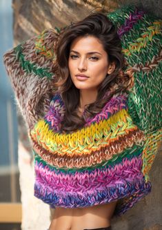 a woman wearing a multicolored knitted shawl