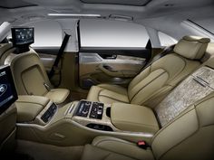 the interior of a luxury car with beige leather seats and dashboards, including an entertainment center