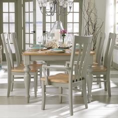 a dining room table with chairs and plates on it