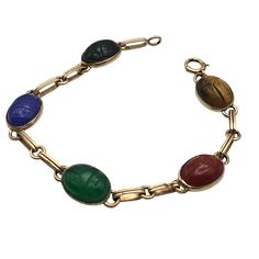 This Vintage Symmetallic Bracelet Features Intricately Carved Scarabs Set In Sterling Silver With 14k Gold Vermeil Accents. Each Scarab, Crafted From Vibrant, Colored Stones, Adds A Touch Of Elegance And Historical Significance. The Bracelet's Classic Design Is A Nod To Ancient Egyptian Artistry, Making It A Timeless Piece For Collectors. Intricate Scarab Design Sterling Silver & 14k Gold Colored Stone Scarabs Classic Clasp Closure 7.25 Inches Length Bracelet Measures 7.25 Inches In Length. Nice Estate Condition Width: Approx. 3/8 " Cabochons Features: Made In Usa Size: Womens 7 1/4 Inch Condition: Pre-Owned Good Nice Estate Condition Scarab Bracelet, Colored Stones, Colored Stone, Gold Overlay, Ancient Egyptian, Womens Jewelry Bracelets, Gold Vermeil, Timeless Pieces, Stone Color