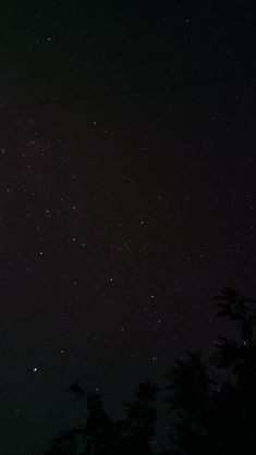 the night sky is filled with stars and trees in front of some power lines that are connected to wires