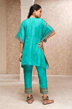 Blue V neck kaftan top with mirror, thread and sequin embroidery. Paired with a pant.
Components: 2
Pattern: Embroidered
Type Of Work: Mirror, Thread, Sequin
Neckline: V Neck
Sleeve Type: Short
Fabric: Cotton Silk
Color: Blue
Other Details: 
Weight: Approx 1000 gms
Length:
Kaftan: 32 inches
Pant: 36 inches
Model height: 5 ft. 7 inches, wearing size S
Occasion: Mehendi and Haldi - Aza Fashions V Neck Kaftan, Embroidered Kaftan, Kaftan Top, Pant For Women, Sequin Embroidery, Sequins Embroidery, Blue V, Embroidered Silk, Cotton Silk