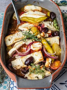 a pan filled with chicken and vegetables on top of a table