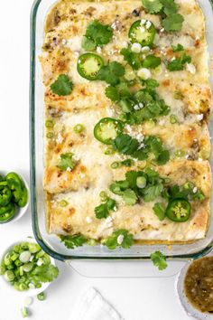 an enchilada casserole with green peppers and onions in a glass dish