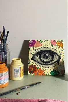 an eye is painted on the wall next to some crafting supplies