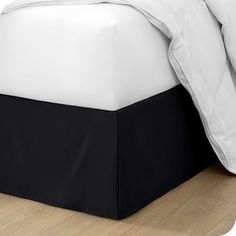 a bed with white and black sheets on it