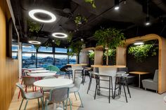 an office with plants growing on the walls and tables in front of it, along with chairs